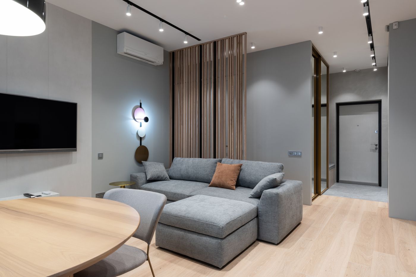 Modern apartment living room with a gray sofa and wood finishes